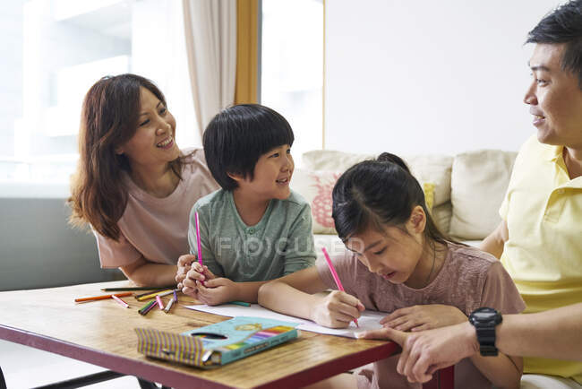 RILASCIO Felice giovane famiglia asiatica insieme disegno a casa — Foto stock