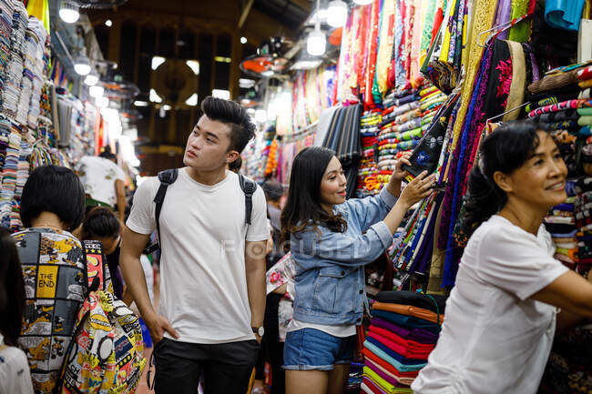 Jovem casal vietnamita procurando roupas um mercado em Saigon, Vietnã — Fotografia de Stock