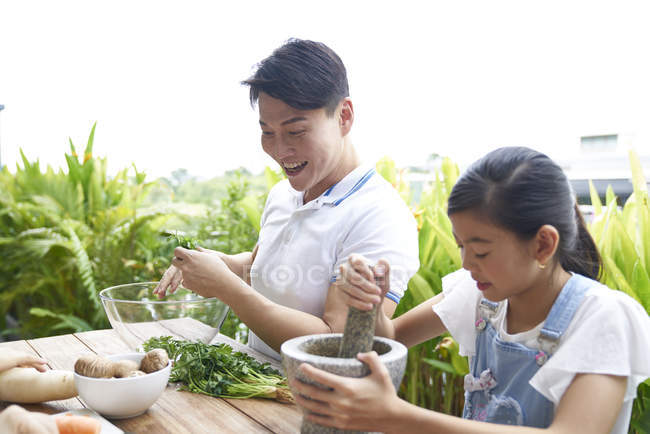 Счастливый азиатский отец и дочь готовят еду вместе дома — стоковое фото