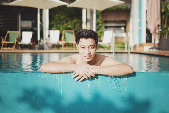 Jeune homme asiatique attrayant relaxant dans la piscine — Photo de stock