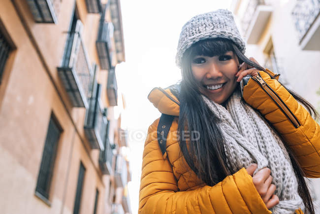 Junge attraktive asiatische Frau mit Smartphone auf der Straße — Stockfoto