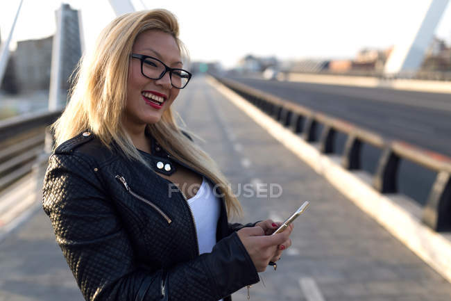 Femme blonde chinoise avec smartphone à Barcelone — Photo de stock