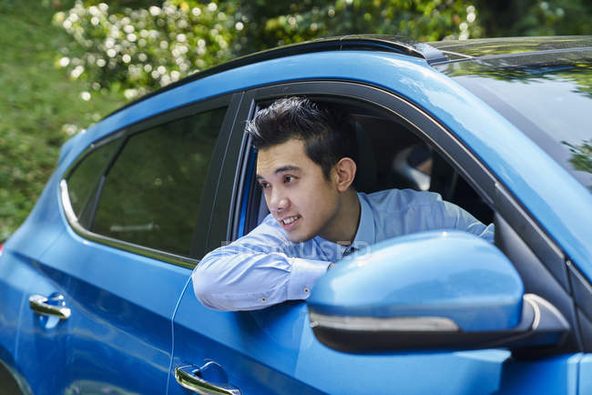 Jeune conducteur mâle regardant par la fenêtre de la voiture — Photo de stock