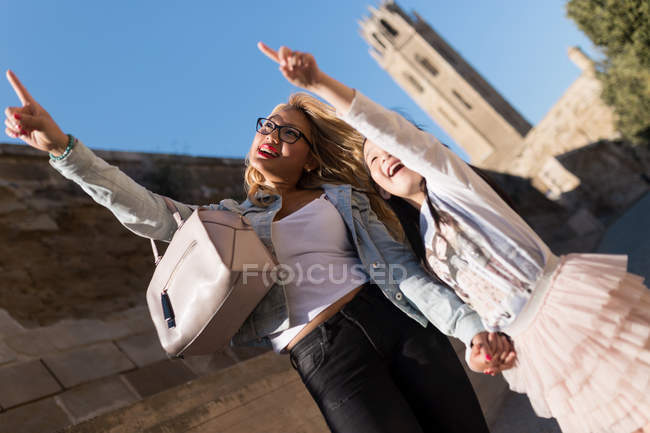 Retrato de jovem mãe feliz com sua filha curtindo a cidade em um dia ensolarado . — Fotografia de Stock