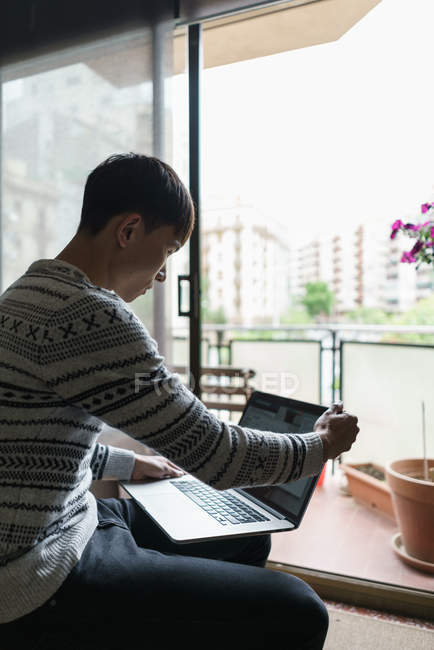 Дорослий азіатських юнак використання ноутбука на дому — стокове фото