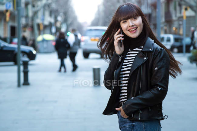 Giovane attraente donna asiatica in città utilizzando smartphone — Foto stock