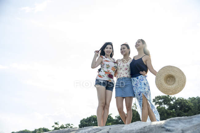 Three young ladies enjoying the breeze. — Stock Photo