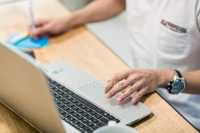 Imagem cortada do homem que trabalha com laptop no escritório — Fotografia de Stock