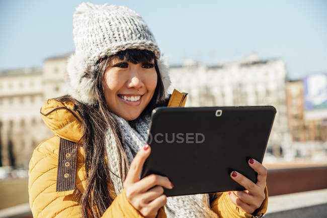 Giovane attraente asiatico donna utilizzando tablet su strada — Foto stock
