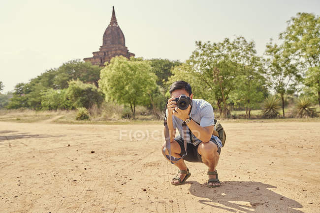 Joven con su cámara réflex digital en Pagoda, Myanmar - foto de stock