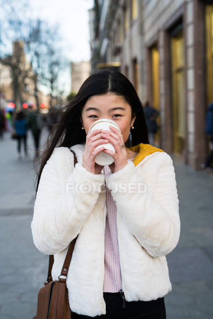 Jeune Chinoise buvant du café dans les rues de Barcelone — Photo de stock