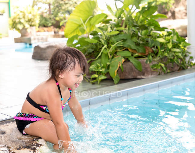 Young little asian toddler girl playing in swimming pool — Stock Photo