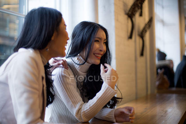 Two beautiful asian women together in cafe — Stock Photo