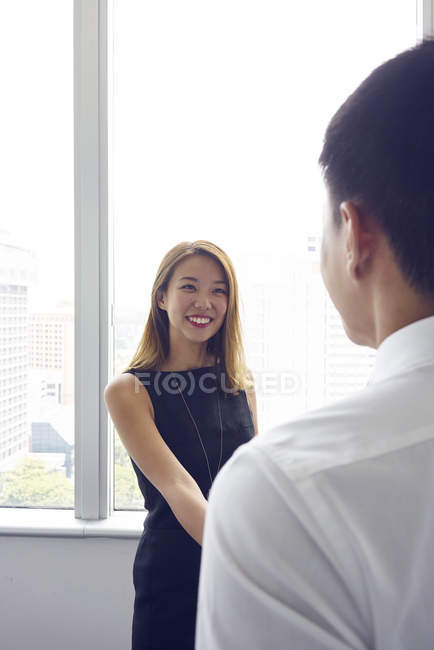 Young asian business woman shaking hands with man at modern office — Stock Photo