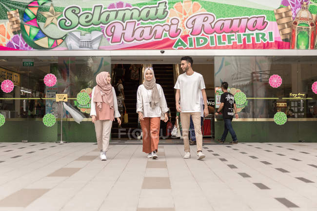 Three friends coming from mall — Stock Photo