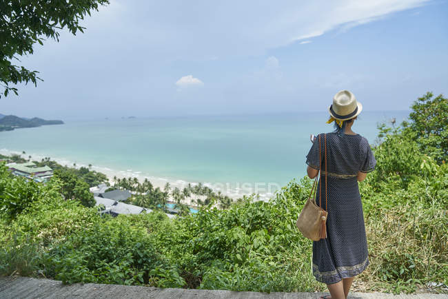 Vista trasera de una joven mujer contra una vista aérea de Koh Chang, Tailandia - foto de stock