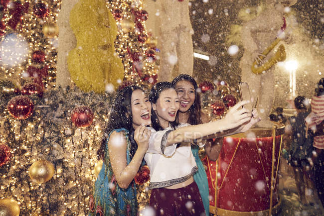Joven atractivo asiático mujeres en Navidad compras tomando selfie - foto de stock