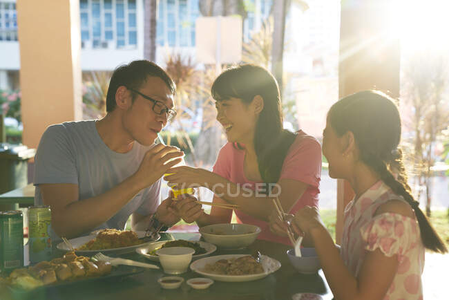 RELEASES Happy young asian family eating together in cafe — Stock Photo
