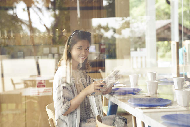 Молодая симпатичная женщина смотрит на камеру в кафе — стоковое фото