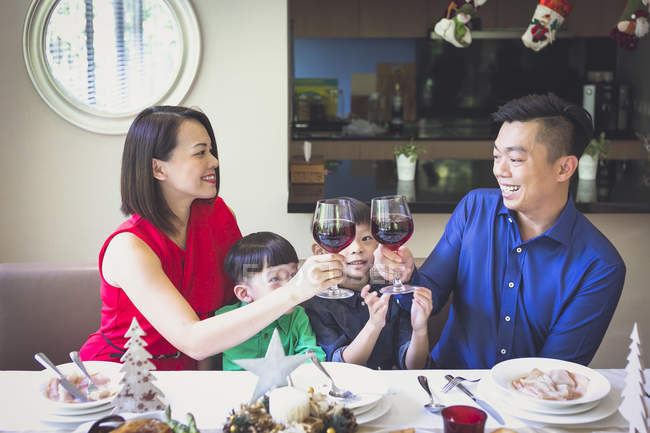 Família cingapuriana de quatro desfruta de um jantar festivo em sua bela casa durante as férias de Natal . — Fotografia de Stock