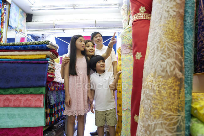 Счастливая молодая азиатская семья вместе на уличном рынке — стоковое фото