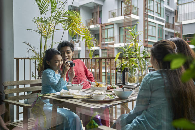 Junge asiatische Familie feiert Hari Raya in Singapore und fotografiert mit der Kamera — Stockfoto