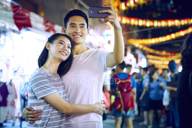 Junges asiatisches Paar verbringt Zeit zusammen auf traditionellem Basar zum chinesischen Neujahr und macht Selfie — Stockfoto