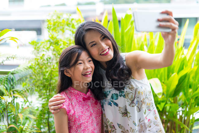 Heureux asiatique femme et fille prise selfie sur smartphone — Photo de stock