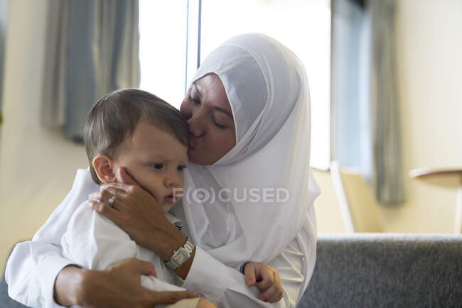 Mother in Hijab playing with her son in the living room — Stock Photo