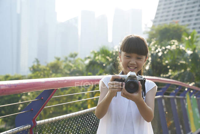 Jovencita divirtiéndose con una cámara en Gardens by the Bay, Singapur - foto de stock