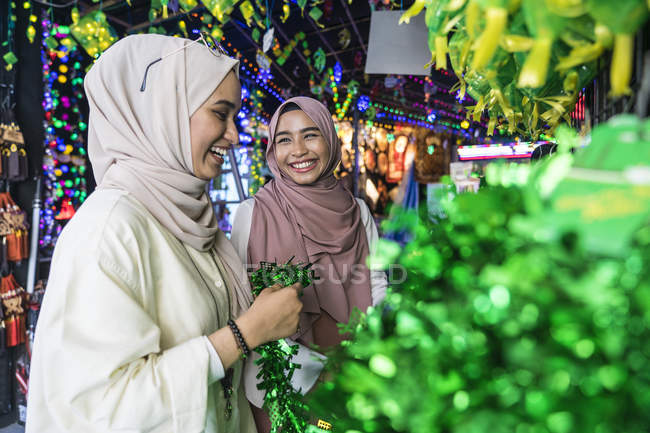 Dos damas musulmanas comprando decoraciones hari raya . - foto de stock
