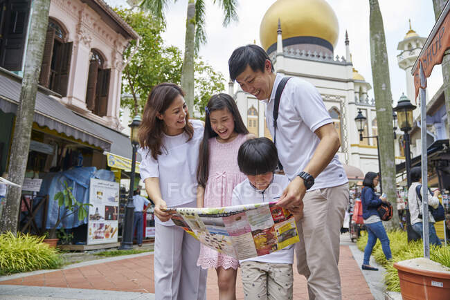 Счастливая молодая азиатская семья вместе путешествует по Арабской улице в Сингапуре — стоковое фото