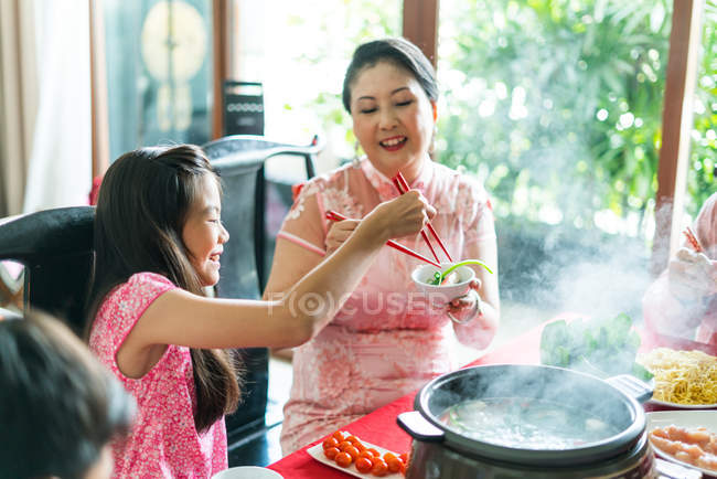 Счастливая азиатская семья вместе едят дома — стоковое фото