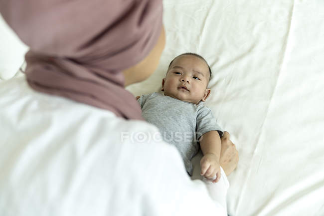 Mãe e bebê deitados na cama em casa — Fotografia de Stock