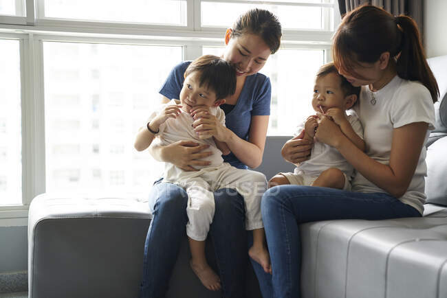 RILASCIO Giovani madri che legano con i loro figli in soggiorno — Foto stock