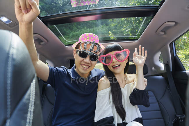 Casal se divertindo no banco de trás de um carro — Fotografia de Stock