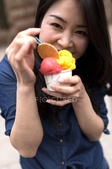 Retrato de una hermosa joven comiendo helado en las calles de Barcelona, España - foto de stock