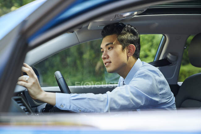 Junger männlicher Fahrer sucht auf seinem GPS nach dem Weg — Stockfoto