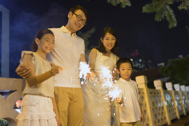 RILASCIA giovane famiglia asiatica insieme con scintille a Capodanno cinese — Foto stock