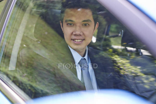 Jovem motorista alegre em um terno — Fotografia de Stock