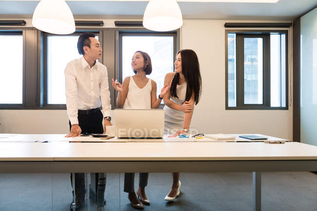 Молодые азиаты, работающие вместе в современном офисе — стоковое фото