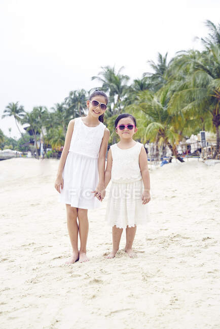 RELEASES Two little sisters spending time together on beach — Stock Photo