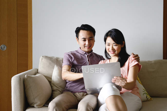 Взрослые азиатские пары вместе с помощью ноутбука дома — стоковое фото