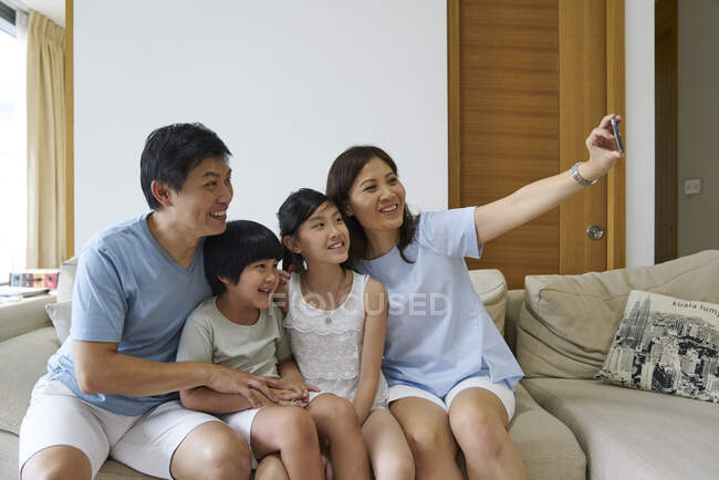 RELEASES Happy young asian family together taking selfie at home — Stock Photo