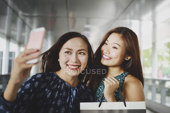 Joven atractivo asiático las mujeres tomando selfie con la bolsa de compras - foto de stock