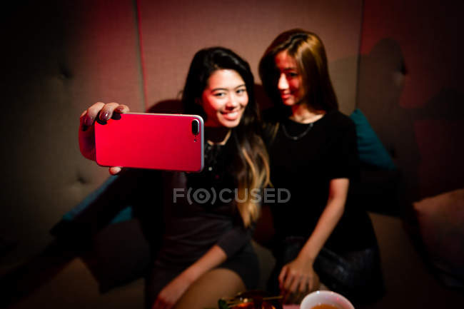 Good girlfriends taking selfie in night club — Stock Photo