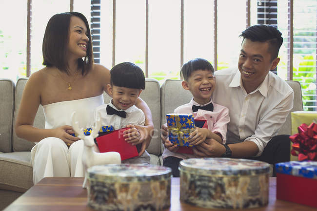 Glückliche vierköpfige Familie feiert Weihnachten in ihrem Haus in Singapore. — Stockfoto