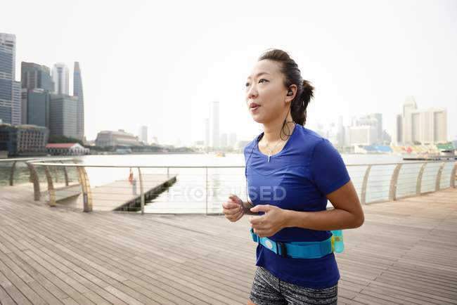 Jeune sportive asiatique femme courir à parc — Photo de stock
