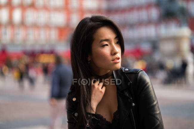 Chinês jovem e bonita mulher na Plaza Mayor de Madrid, Espanha, vestindo uma jaqueta de couro — Fotografia de Stock