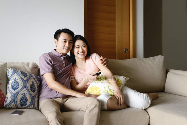 Jovem casual asiático casal assistindo tv em casa — Fotografia de Stock